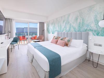 Modernes Hotelzimmer mit Doppelbett, Balkon und Meerblick.