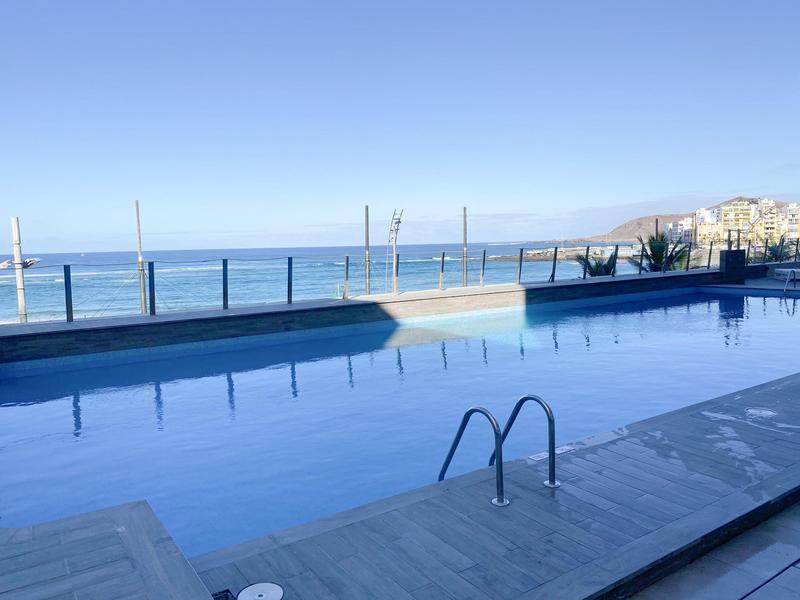 Piscine avec vue sur l'océan et balustrade par une journée ensoleillée à l'hôtel