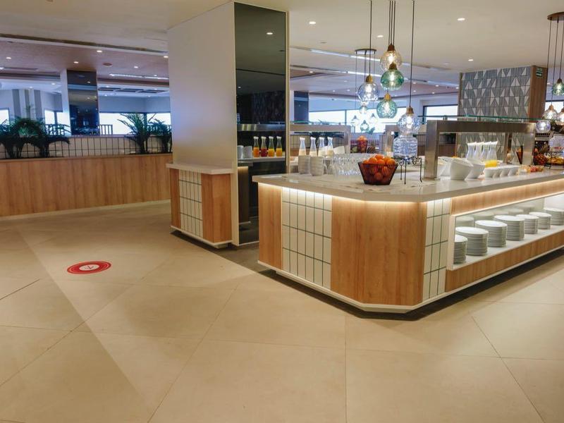 Cuisine d'hôtel moderne et lumineuse avec de grandes stations de cuisson et un design ouvert.