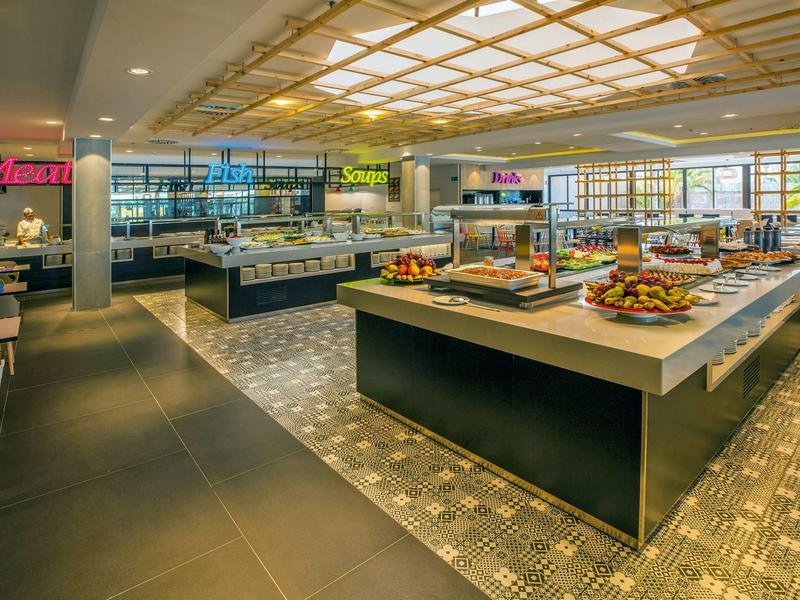 Restaurant buffet moderne avec stations de nourriture et intérieur lumineux.