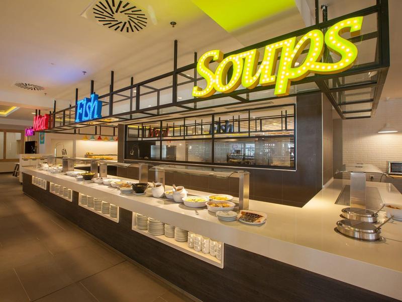 Buffet moderne avec panneaux éclairés pour soupes et salades dans un restaurant d'hôtel.