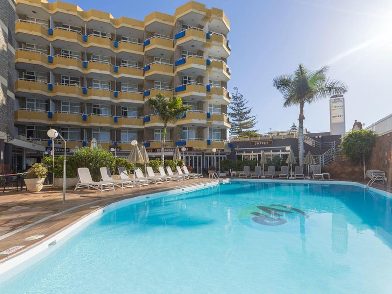 Nowoczesny hotelowy basen z leżakami i palmami pod słonecznym niebem