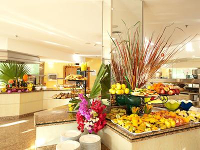 Jasné hotelové buffet s čerstvým ovocem a květinami v prostorné jídelně.
