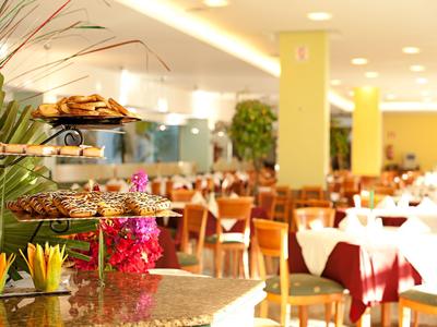 Dobře osvětlená restaurace s prostřenými stoly a bufetem.