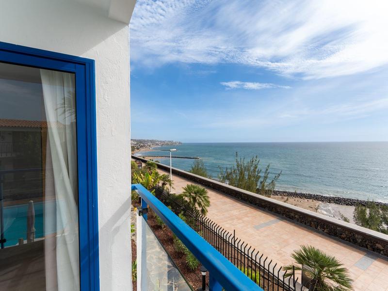Balcone con ringhiera blu con vista sul mare in una giornata di sole