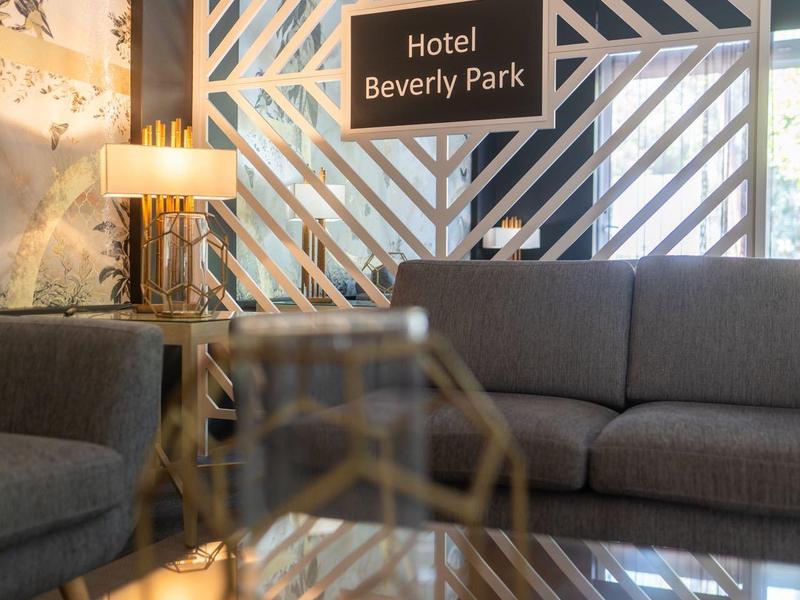 Entrada del hotel con letrero decorativo y sofás modernos en espacio iluminado cálidamente