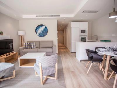 Sala luminosa con muebles modernos, cocina y comedor en un espacio abierto.