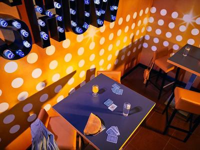 View of a hotel bar table with games and drinks under warm lighting.