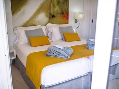 Cozy hotel room with yellow bedspread and stacked towels.