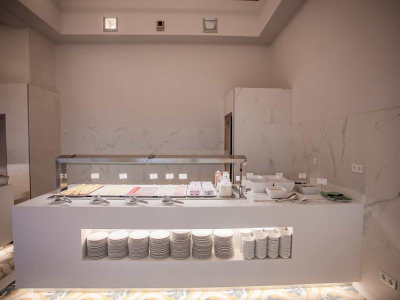 Moderner weißer Küchenblock mit integriertem Kochfeld und mehreren Töpfen und Pfannen.