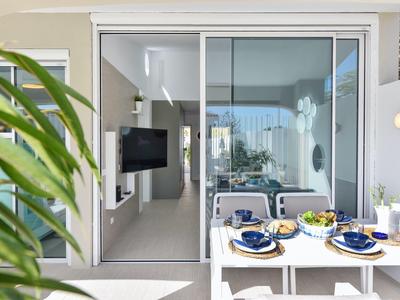 Balkon met eettafel en uitzicht op moderne woonkamer van vakantiewoning