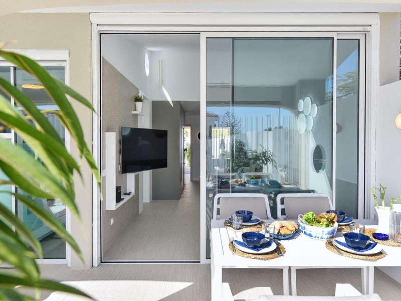 Balkon met eettafel en uitzicht op moderne woonkamer van vakantiewoning