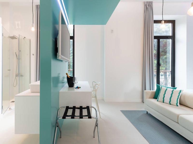 Soggiorno luminoso e moderno con divano, tavolo in vetro e vista sul balcone