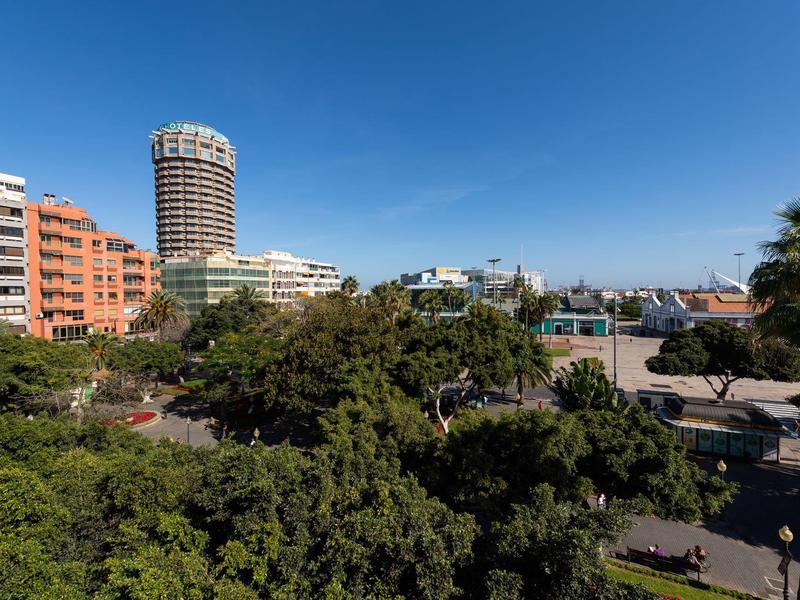 Hotel urbani con architettura moderna e aree verdi sotto un cielo azzurro.
