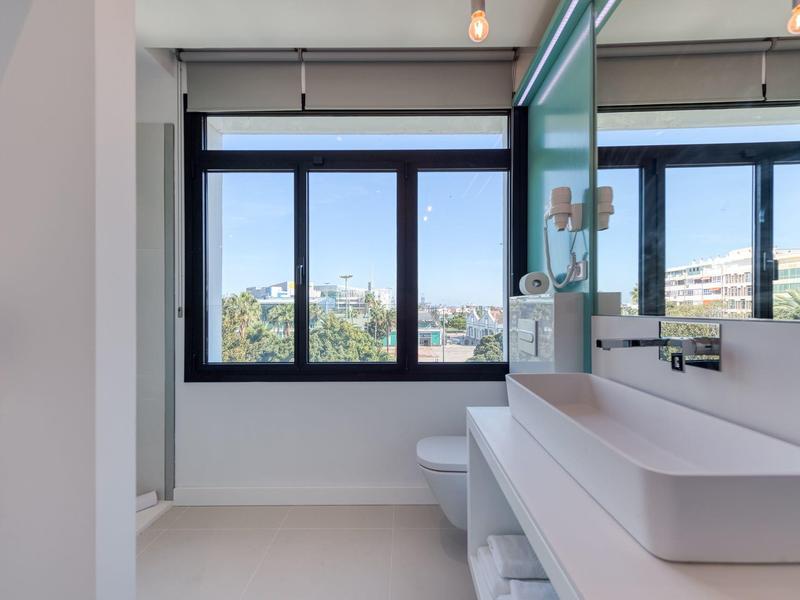 Bagno moderno con grande finestra e lavabo in una camera d'hotel.