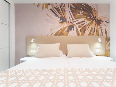 Modernes Hotelzimmer mit zwei Betten und dekorativer Wandgestaltung in warmen Farben