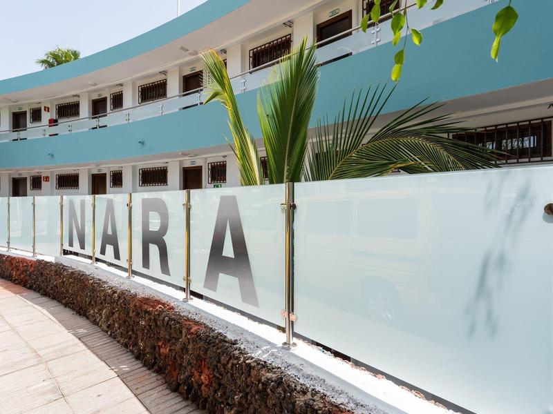 Facade of a hotel with a curved blue building and the sign 'NARIA'.