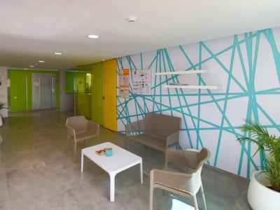 Couloir d'hôtel moderne avec coin salon et design mural coloré.