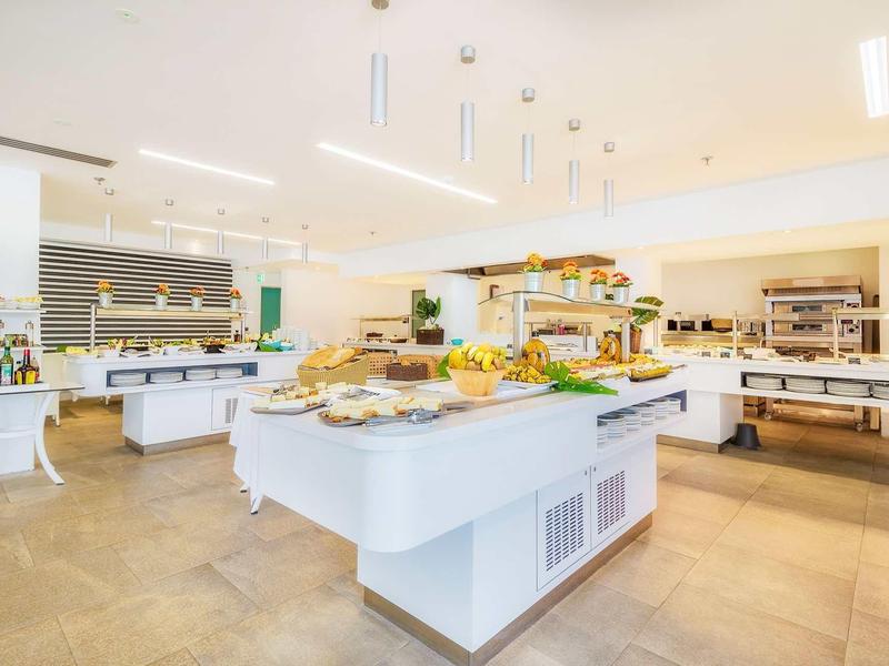 Jasna, nowoczesna sala śniadaniowa z bufetem i różnorodną ofertą.