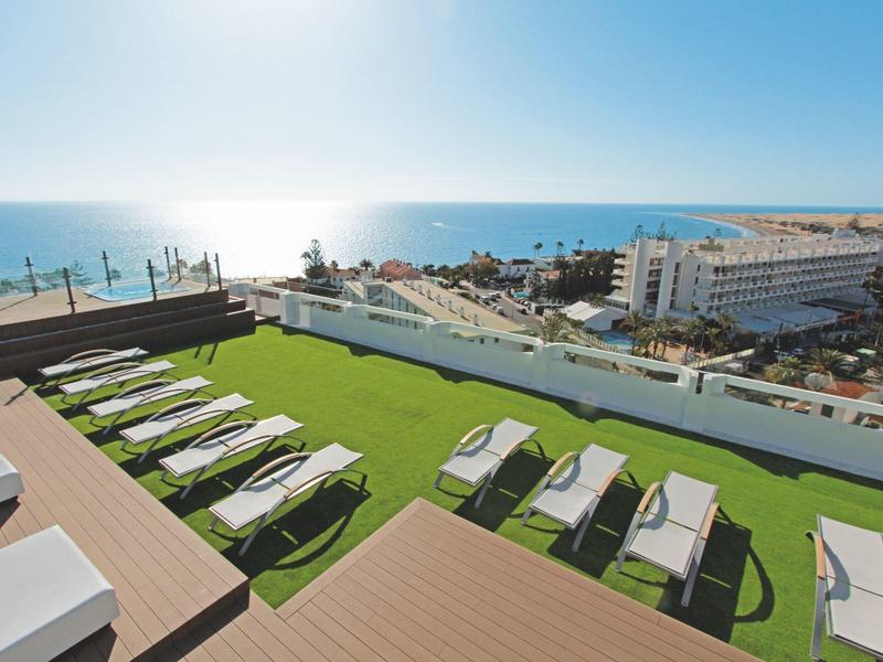 Terrasse sur le toit avec chaises longues, vue sur la mer et la ville