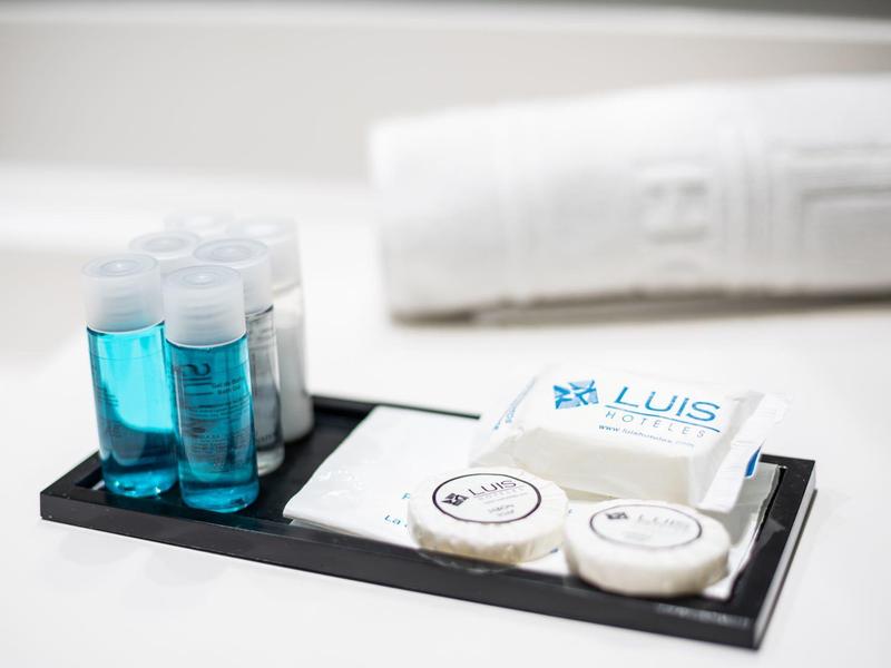 Ensemble de bien-être d'hôtel avec liquide bleu, savon et serviette en arrière-plan.