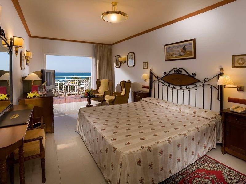 Cozy hotel room with large bed and sea view from the terrace.