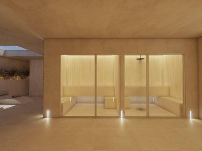 Modern courtyard with comfortable lounge chairs and large glass walls under soft lighting.