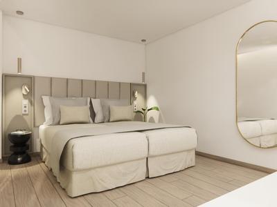Moderne hotelkamer met groot bed, grijs gestoffeerd hoofdeinde en ovale spiegel aan de muur.