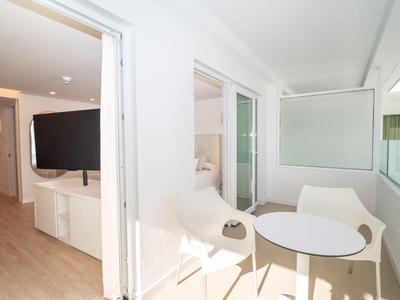 Balkon z okrągłym stołem i dwoma krzesłami w jasnym pokoju hotelowym