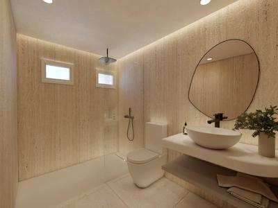 Moderne badkamer met ronde spiegel, wastafel en douche in neutrale tinten.