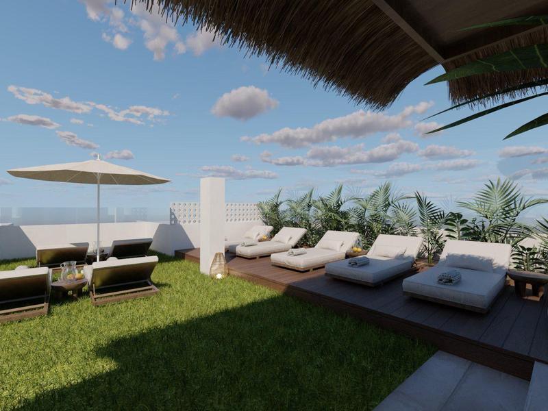 Dakterras met ligstoelen, parasol, groene planten en uitzicht op blauwe lucht.