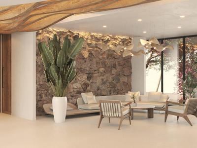 Lichte hotel-lounge met moderne meubels, planten en natuurstenen muur.