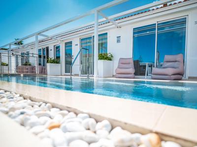 Moderne zwembadomgeving voor een vakantiehuis met ligstoelen en glazen hek