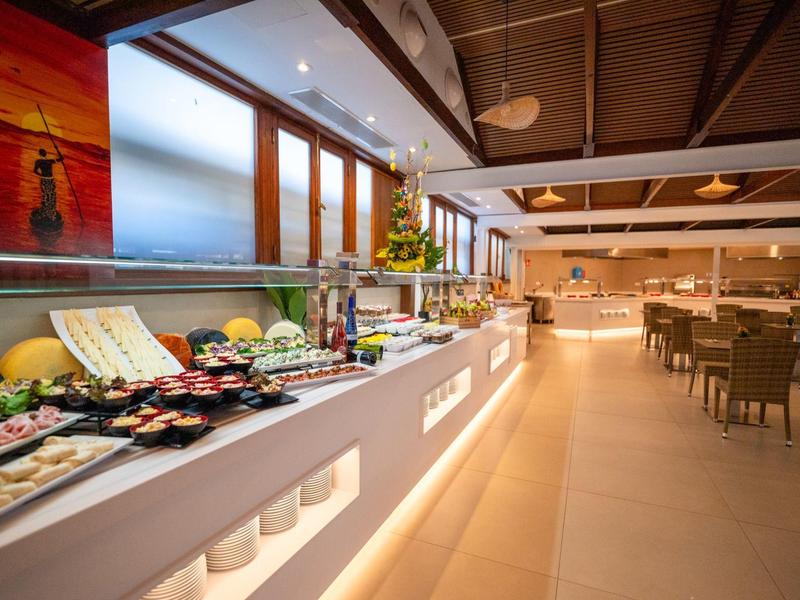 Buffet met verschillende gerechten in een moderne, lichte eetruimte.