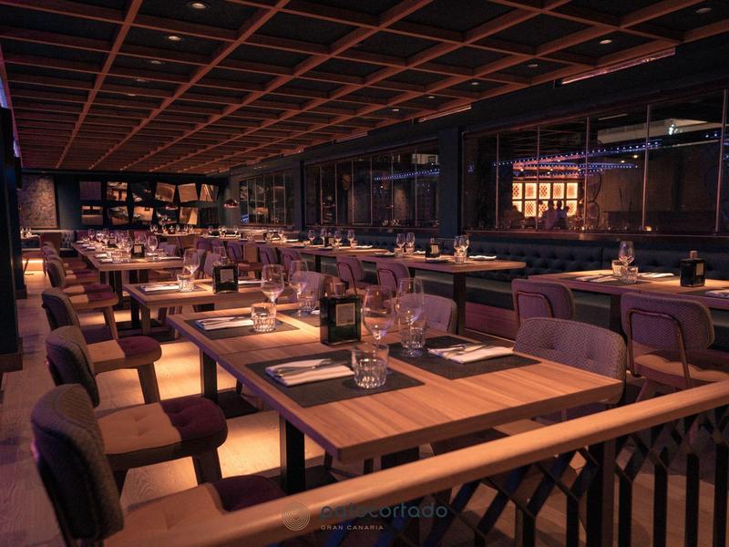 Restaurante elegante con mesas de madera e iluminación tenue para una cena acogedora.