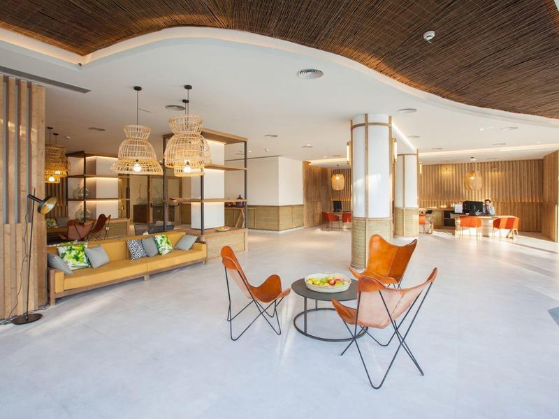 Heller und moderner Hotel-Lobby-Bereich mit elegantem Holzdekor und gemütlichen Sitzplätzen.