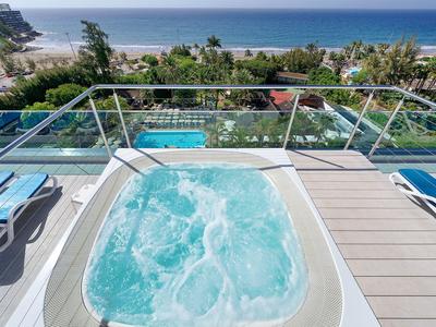 Hot tub on a terrace overlooking the pool and the sea