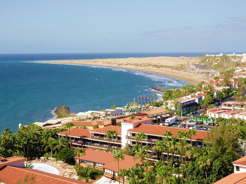 Widok na miasto przy wybrzeżu z plażami, kurortami i niebieskim morzem pod jasnym niebem.