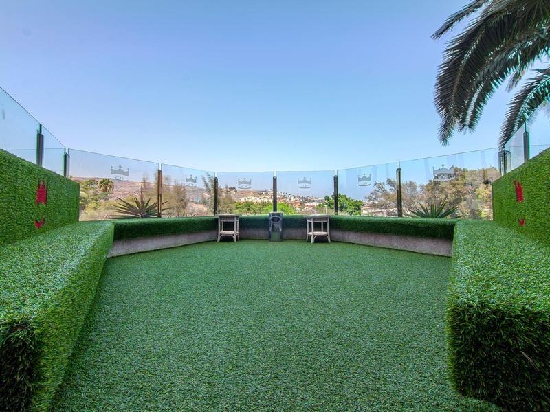 Zadaszone miejsca do siedzenia z żywopłotami po obu stronach oferują widok na góry pod czystym niebem.