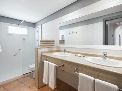 Salle de bain moderne avec double vasque, grand miroir et douche à l'italienne.