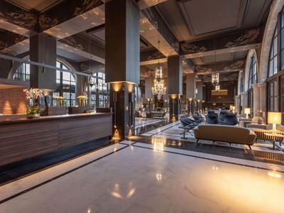 Elegante vestíbulo del hotel con pilares altos, madera oscura y áreas de estar elegantes.