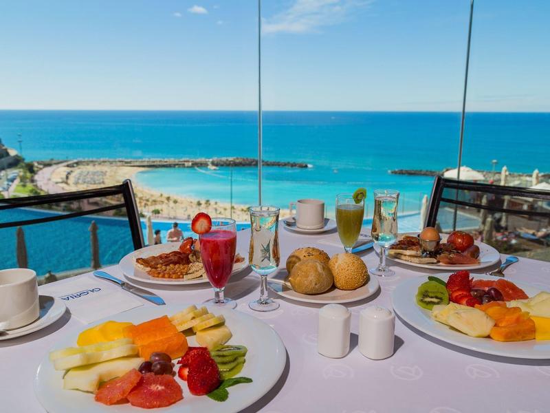 Snídaně s čerstvou šťávou s výhledem na modré moře a čistou oblohu u stolku u moře.