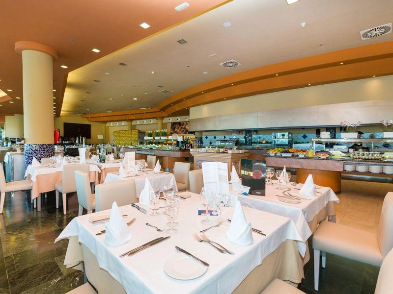 Elegantní restaurace s bílými ubrusy na stolech a jemným osvětlením pro gurmánský zážitek.