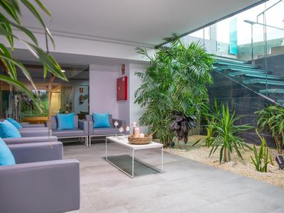Moderní lounge s pohovkami, rostlinami a přímým přístupem k hotelovým schodům.