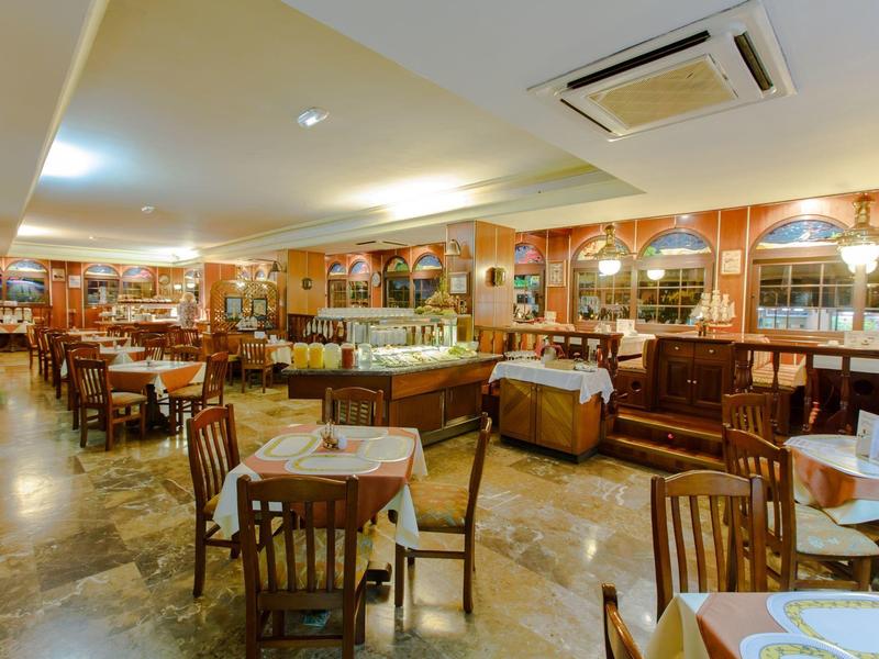 Intérieur de restaurant d'hôtel confortable avec mobilier en bois et tables dressées.