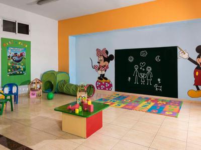 Heldere speelkamer voor kinderen met kleurrijk meubilair, Mickey en Minnie muurschilderingen en speelgoed op een kleed.