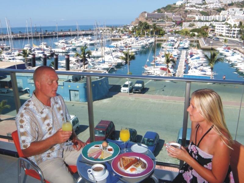 Couple prenant le petit déjeuner avec marina et bateaux en arrière-plan