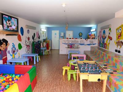 Bunte Kinderspielräume mit Bällebad, Tischen, Fußballkicker und bunten Wanddekorationen.