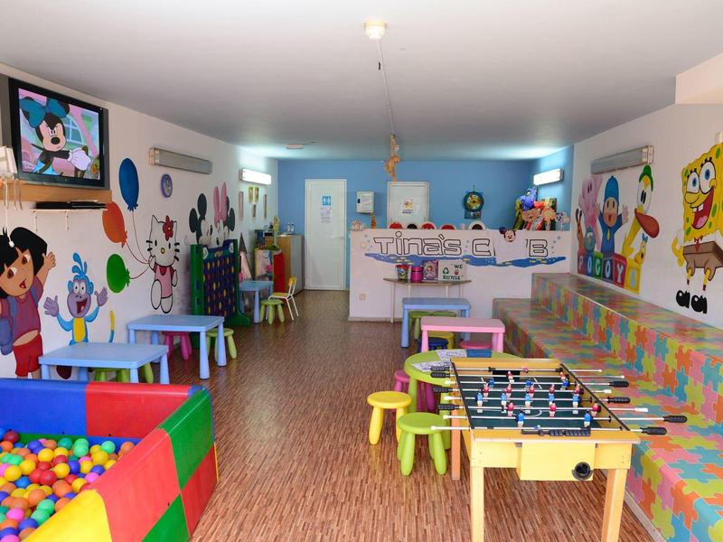 Bunte Kinderspielräume mit Bällebad, Tischen, Fußballkicker und bunten Wanddekorationen.