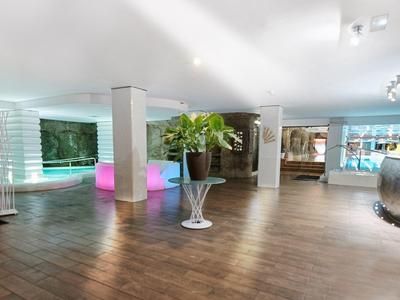 Hall spacieux d'hôtel avec sol en bois, éclairage moderne et décorations élégantes.